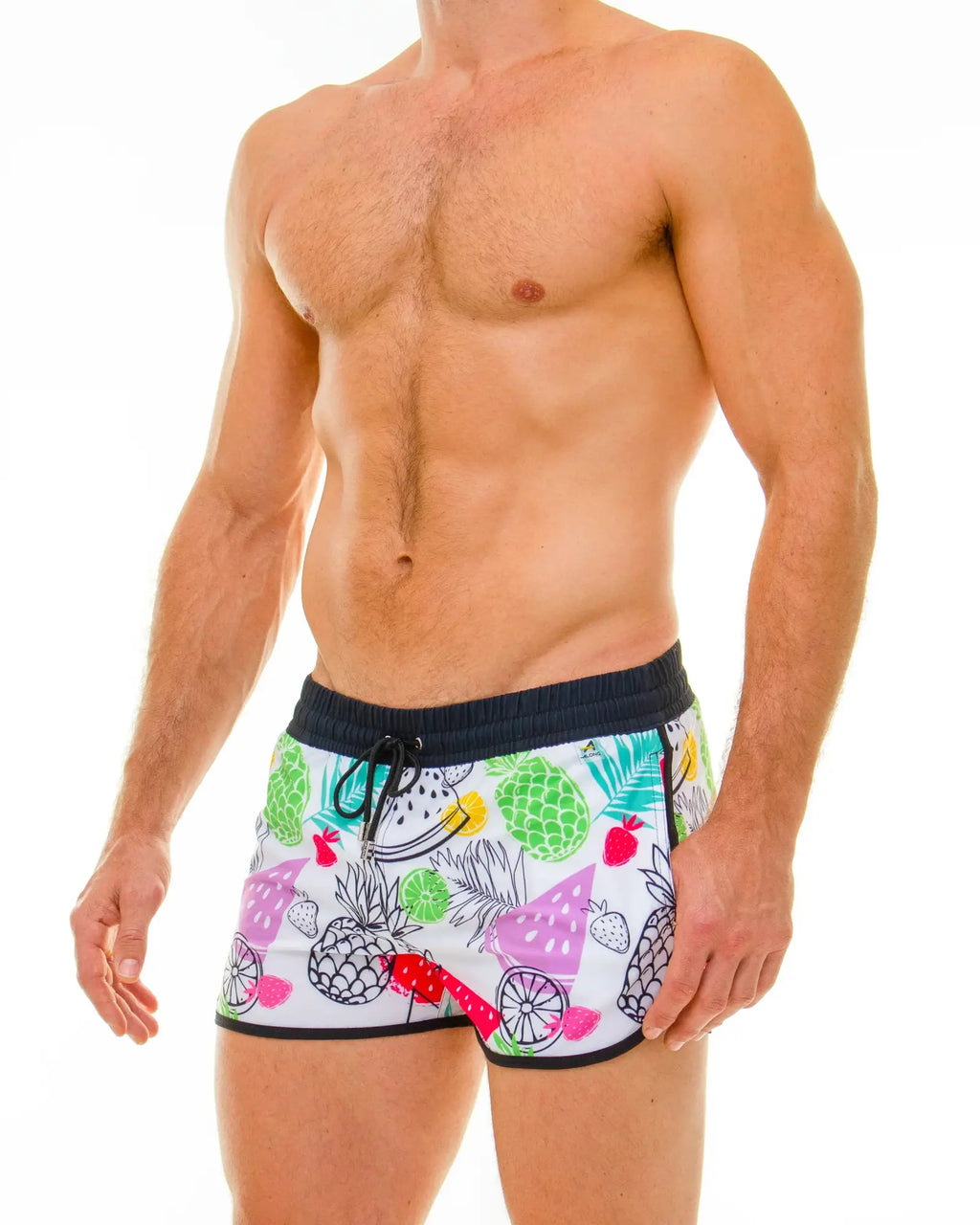 White swim trunks with vibrant tropical fruit pattern featuring pineapples watermelons and strawberries in green pink yellow and purple