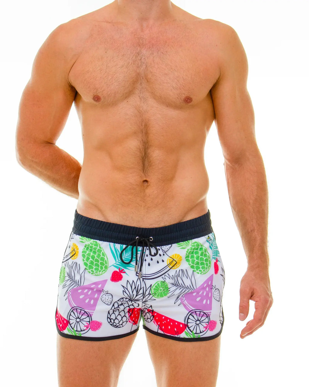 White swim trunks with a vibrant tropical fruit print of pineapples watermelons and strawberries in multiple colors