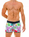 White swim trunks with a vibrant tropical fruit print of pineapples watermelons and strawberries in multiple colors