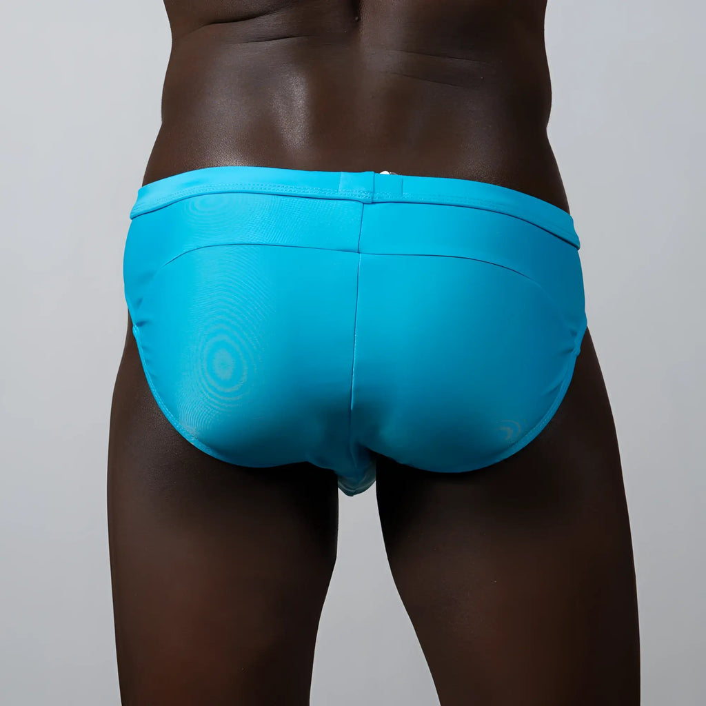 Bright turquoise tulio bikini brief swim trunks with subtle circular pattern and sleek form fitting design