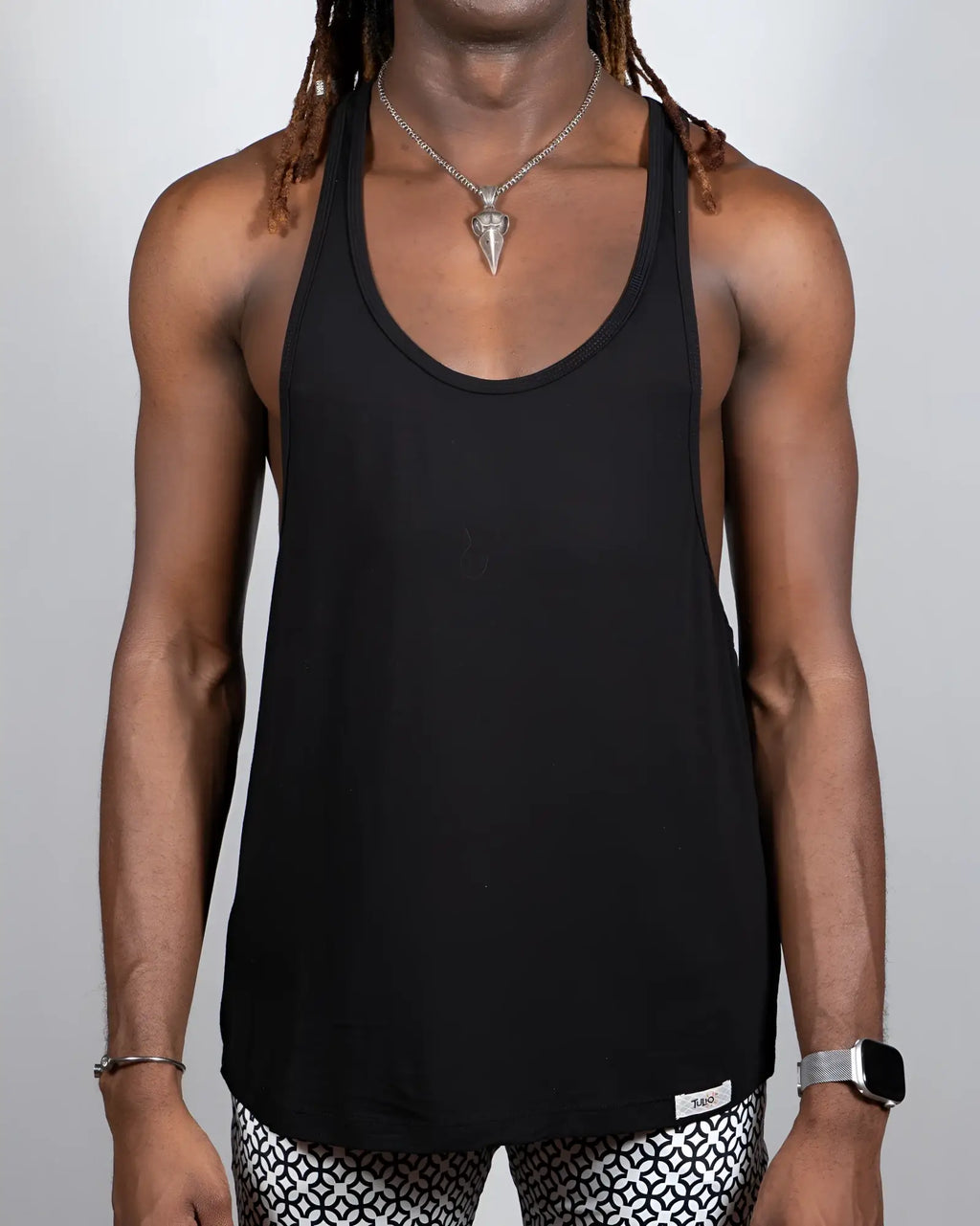 Black racerback tank top with minimalist design and small brand tag at bottom hem tulio racerback tanks 4 colors available