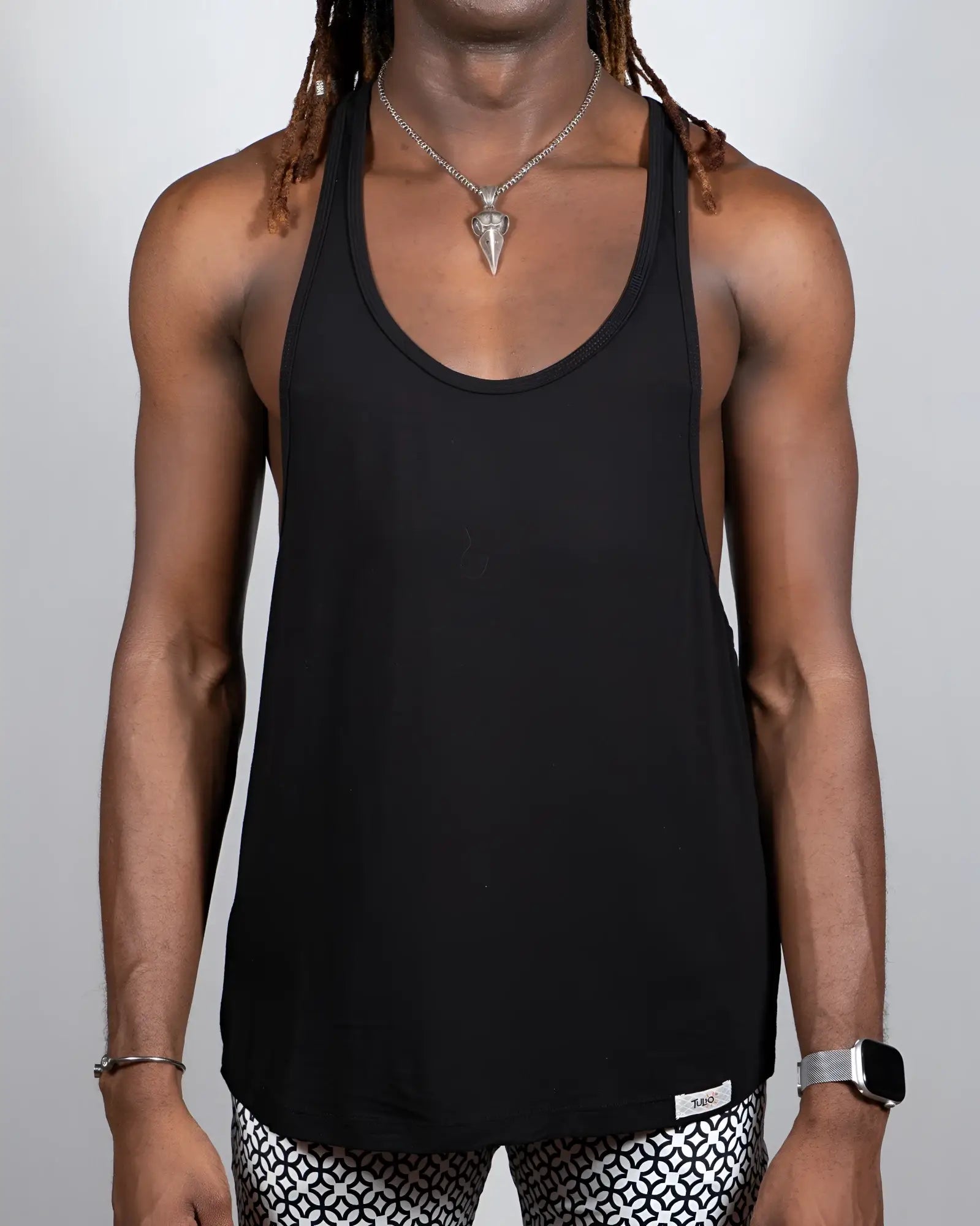 Black racerback tank top with minimalist design and small brand tag at bottom hem tulio racerback tanks 4 colors available