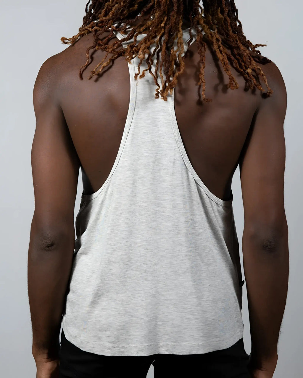 A heather gray tulio racerback tank top with relaxed fit and subtle side seam detailing shown from the back side