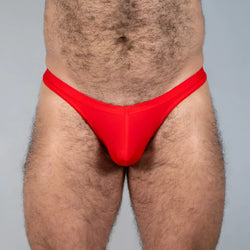 Bright red tulio swim thong made of smooth stretchy fabric with a form fitting design for comfortable swimwear use