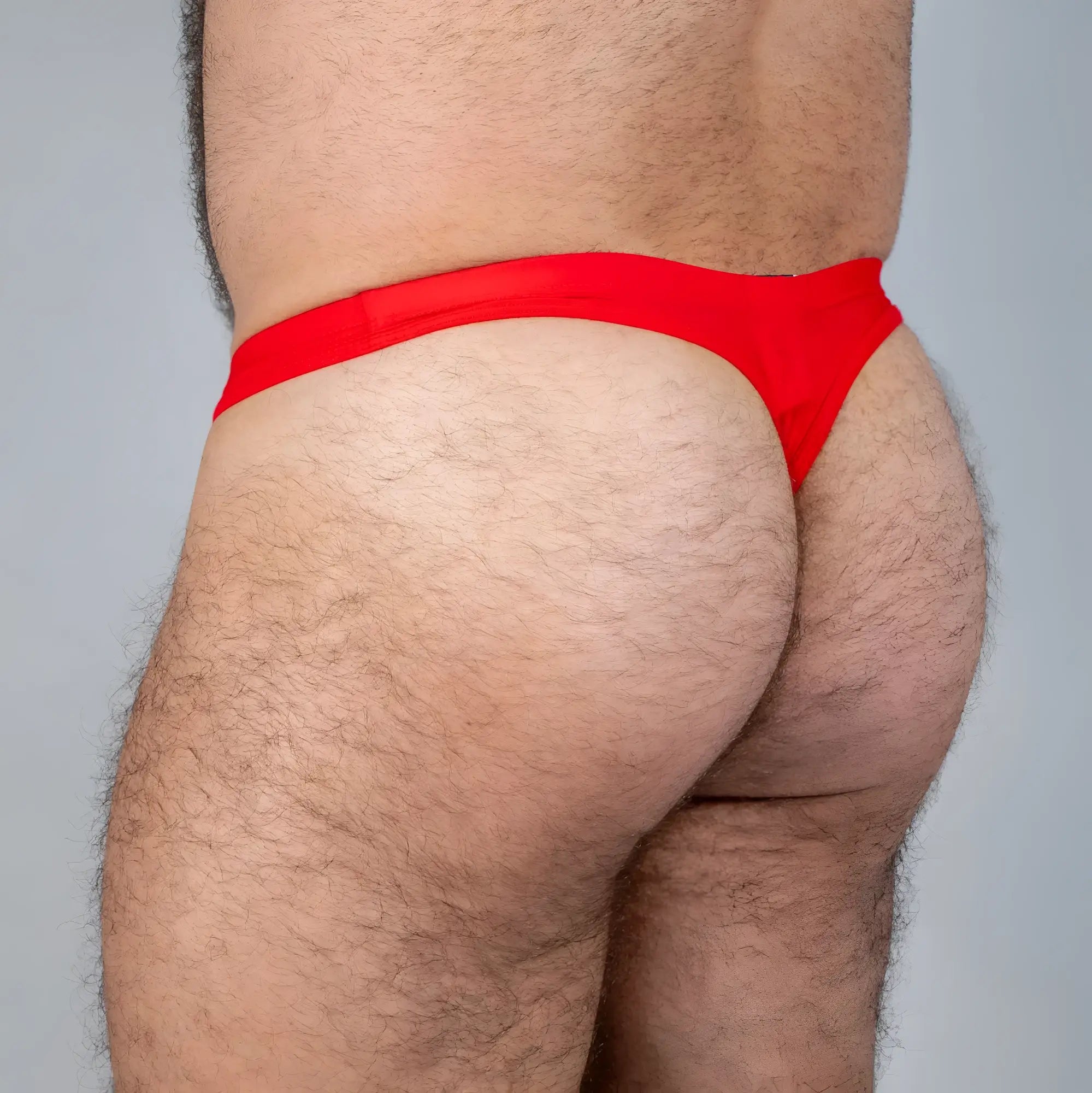 Bright red tulio swim thong made of smooth stretchy fabric designed for swimming and beachwear