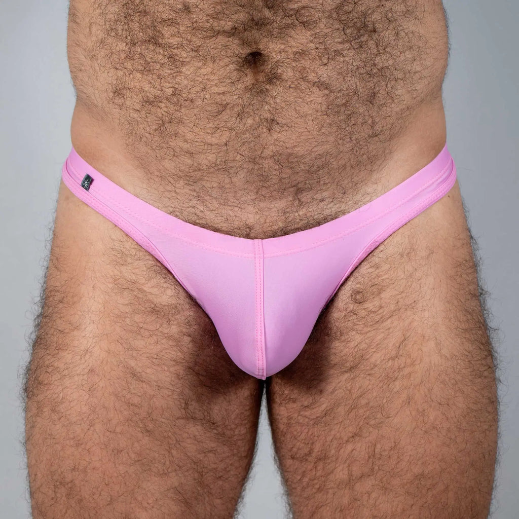 Pink Tulio swim thong made of smooth stretchy fabric with a small black brand tag on the waistband