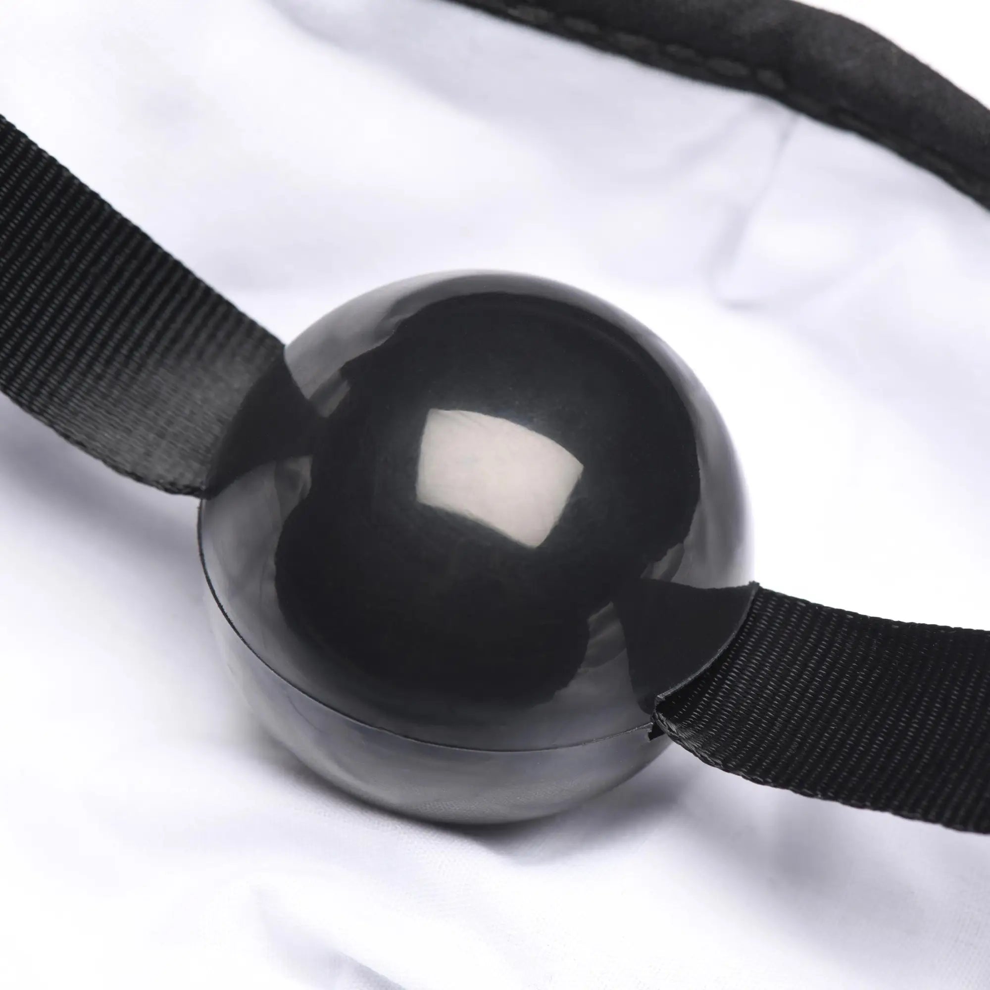 Under Cover ball gag face mask featuring a black glossy spherical gag with black elastic straps for restraint use