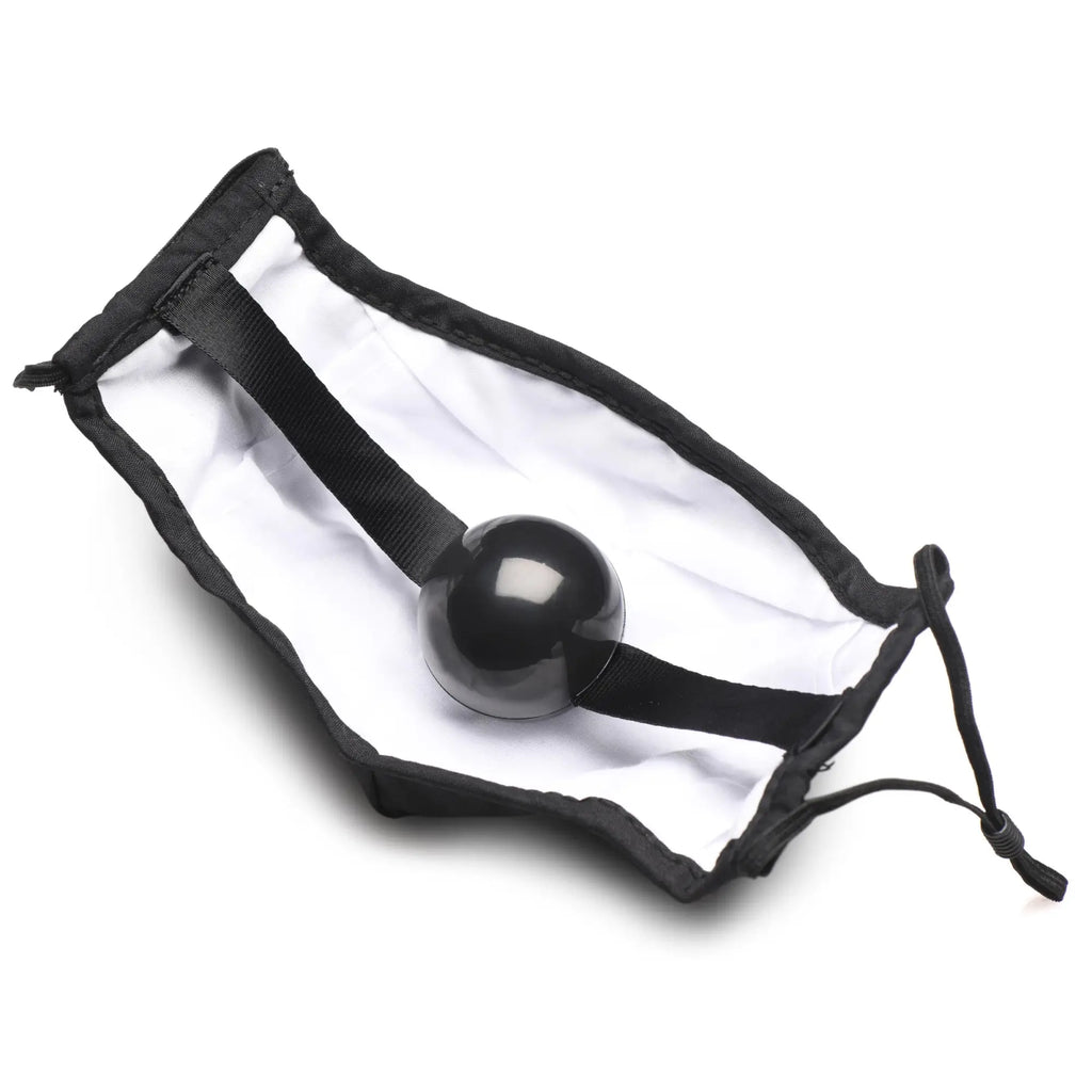 Black spherical ball gag face mask with smooth glossy finish inside a white drawstring pouch lined with black fabric