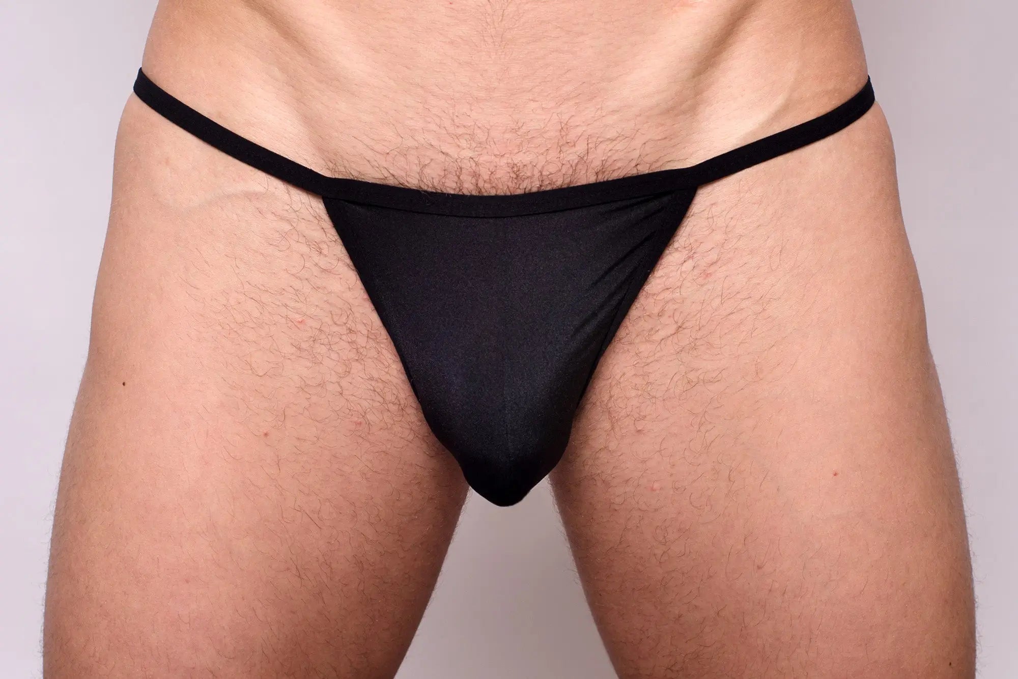 Black thong made of smooth stretchy fabric with narrow waistband shown from the back in 3-pack pride metro string bikini