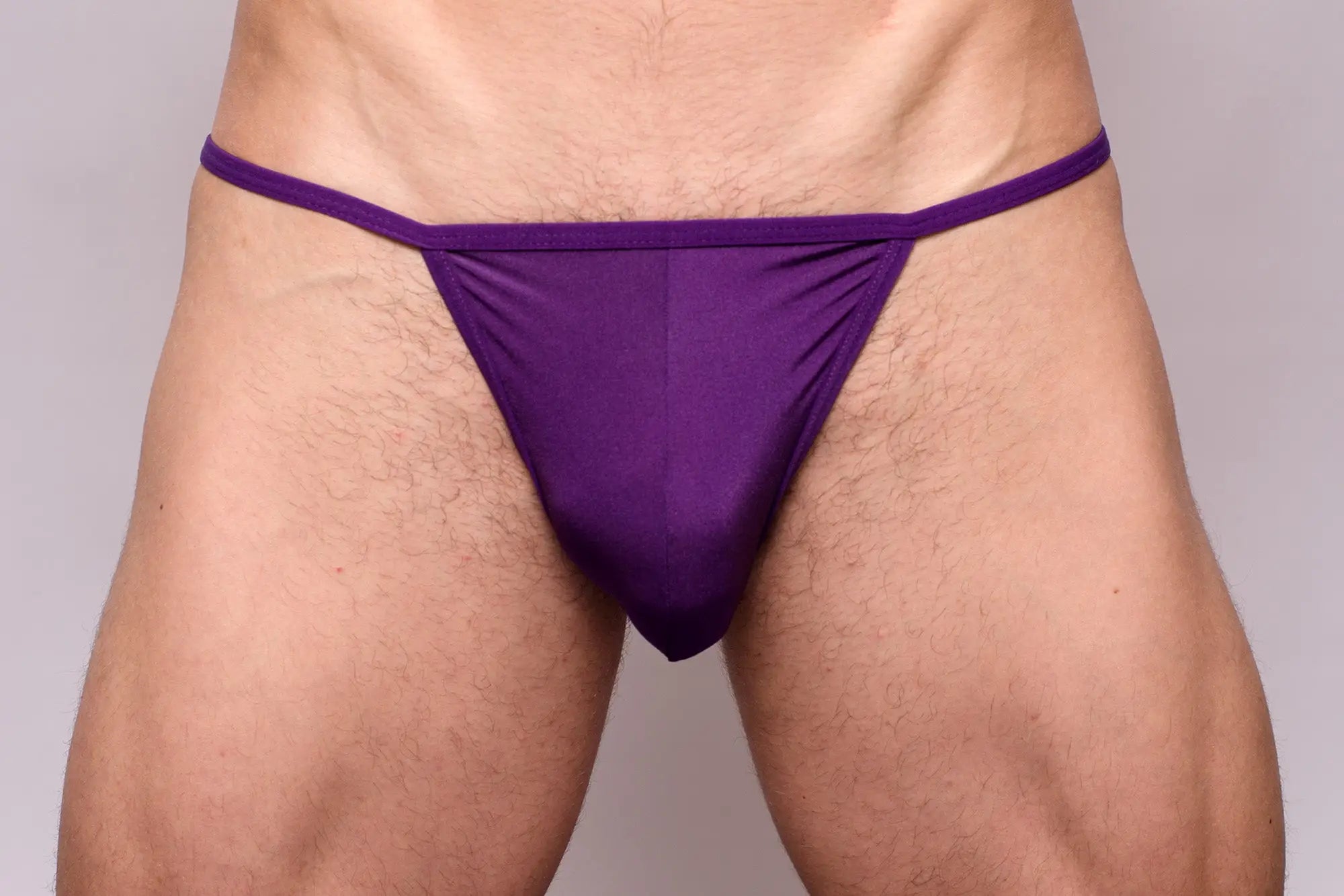Purple thong from 3-pack pride metro string bikini made of smooth stretchy fabric with narrow waistband shown from back