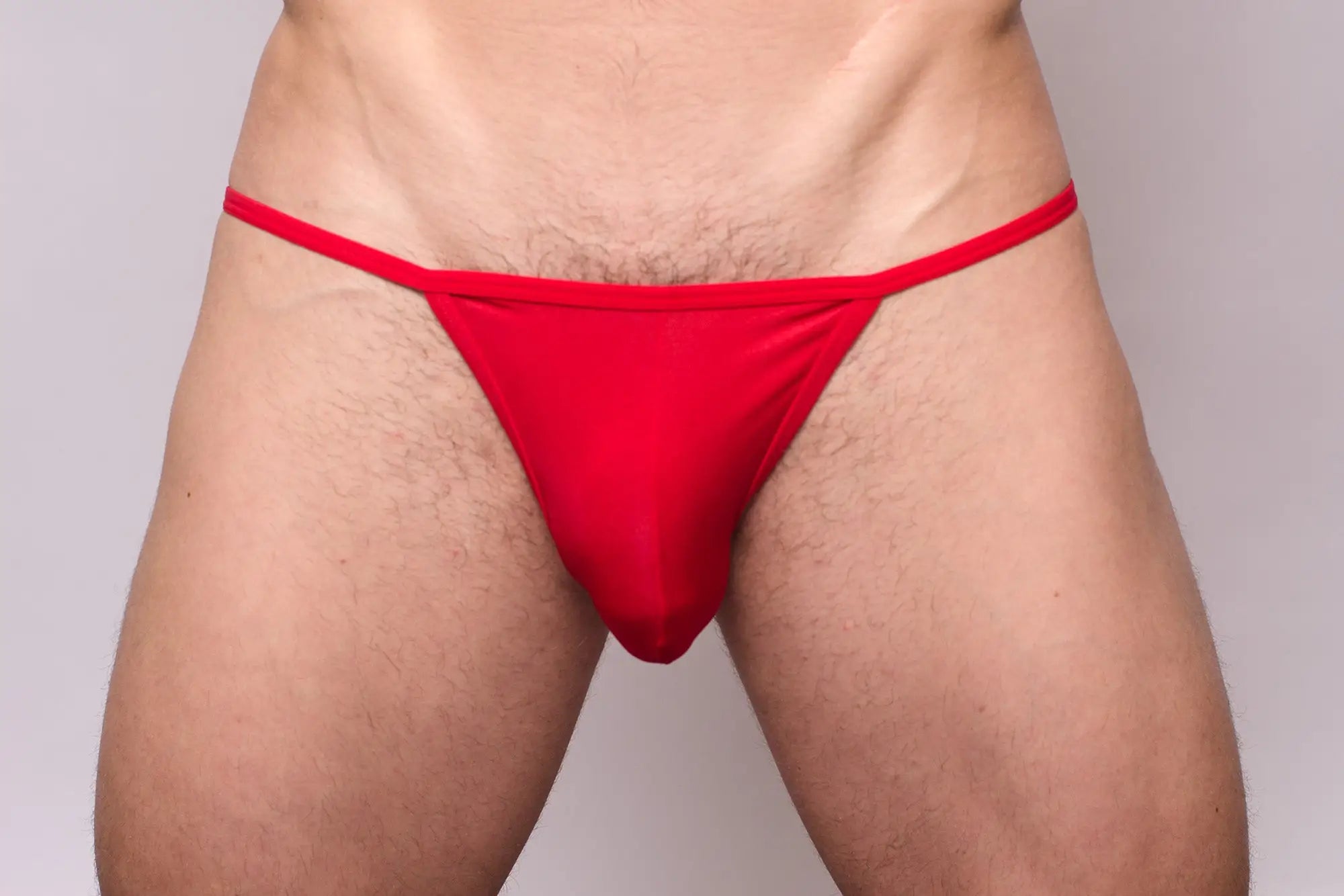 Red thong made of smooth stretchy fabric with a simple design shown from the back in a 3-pack pride metro string bikini