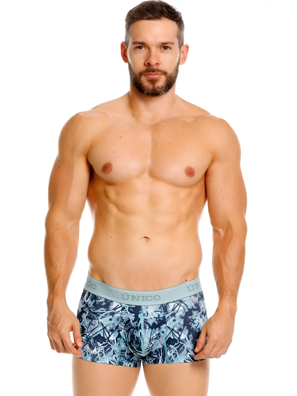 Men’s unico trunks in blue and white tropical leaf pattern with light gray waistband and logo branding