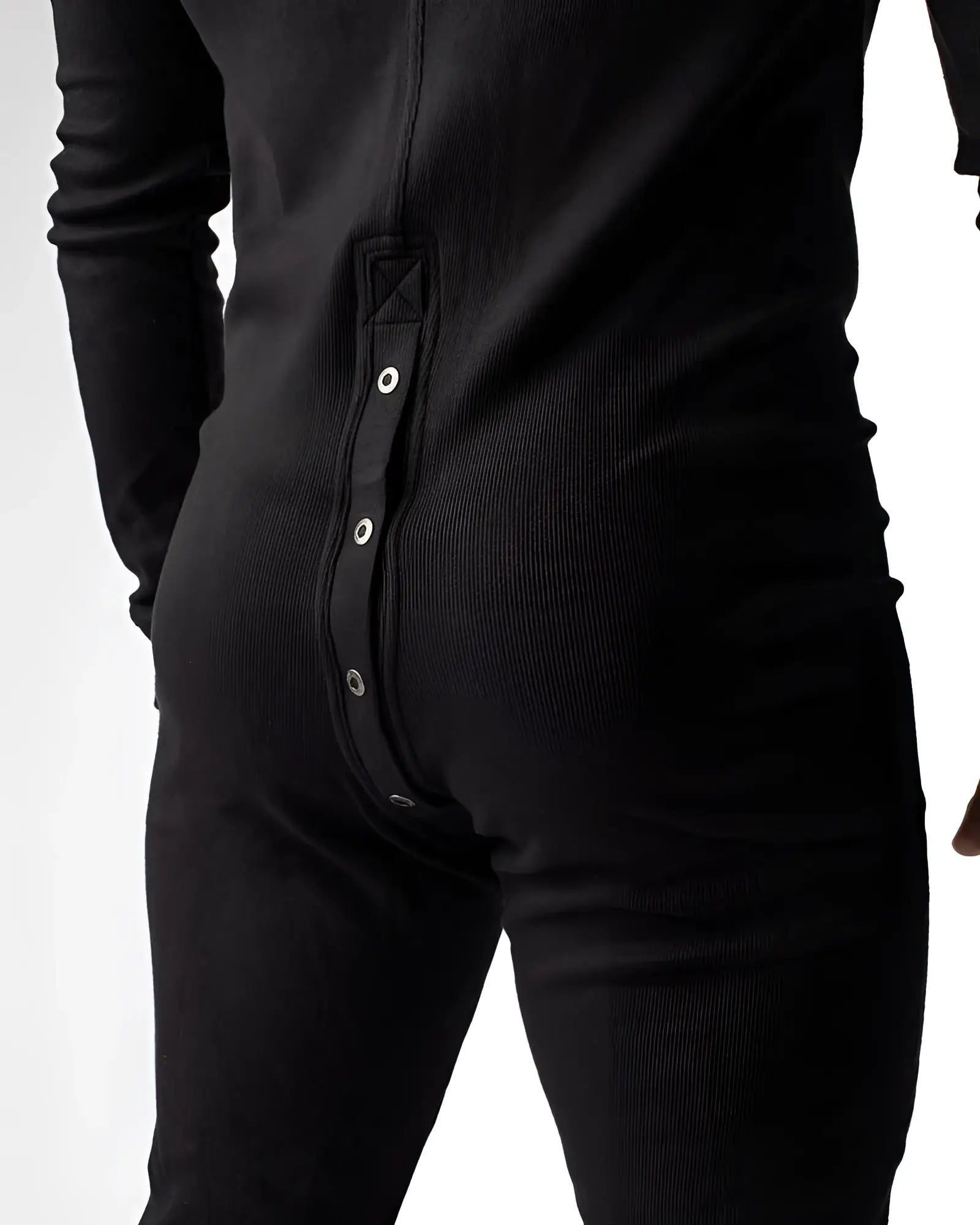 Black ribbed knit union suit one-piece pajama shown from back with vertical silver snap buttons down center