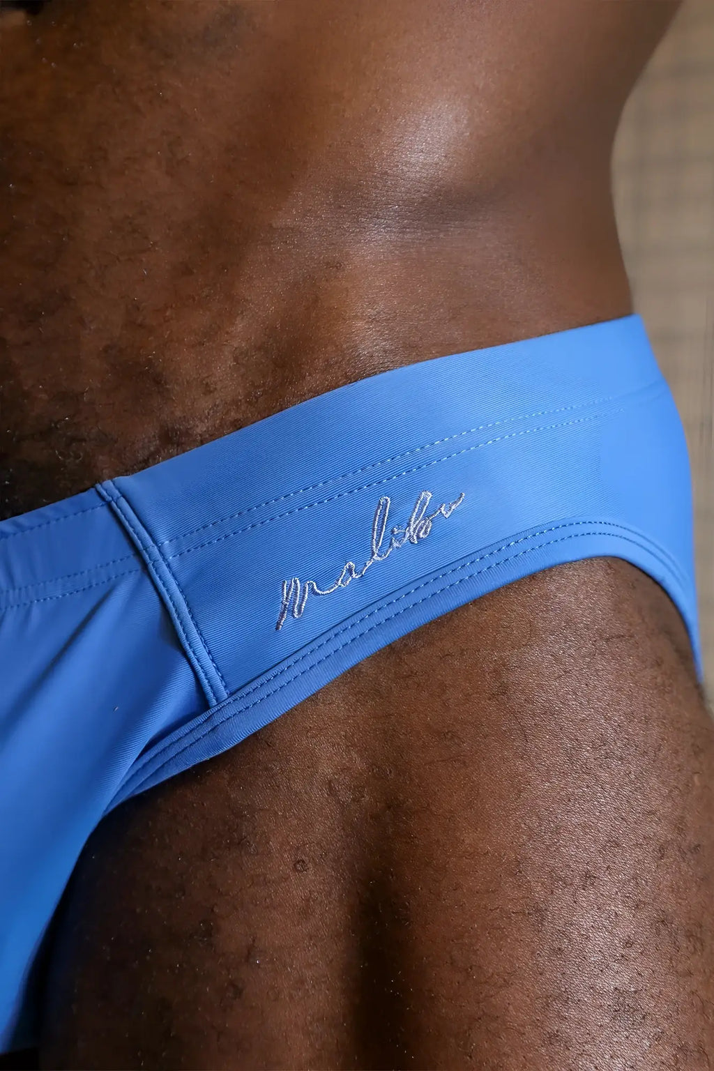 Bright blue unzip me swim briefs featuring a subtle stitched logo on the waistband for swimwear use