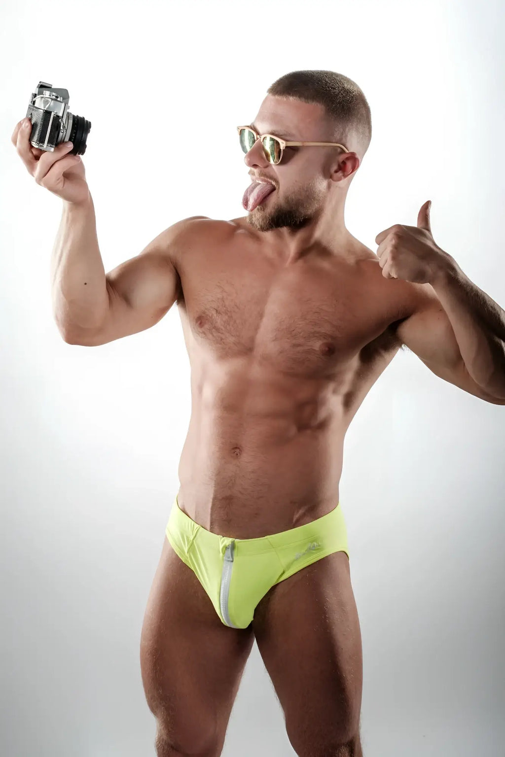 A pair of neon yellow unzip me swim briefs featuring a white zipper detail ideal for swimming and beachwear