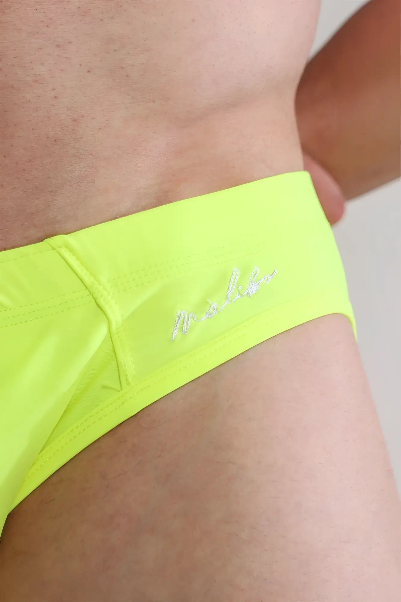Unzip Me swim briefs in neon yellow featuring bright neon yellow fabric and subtle white embroidered logo design