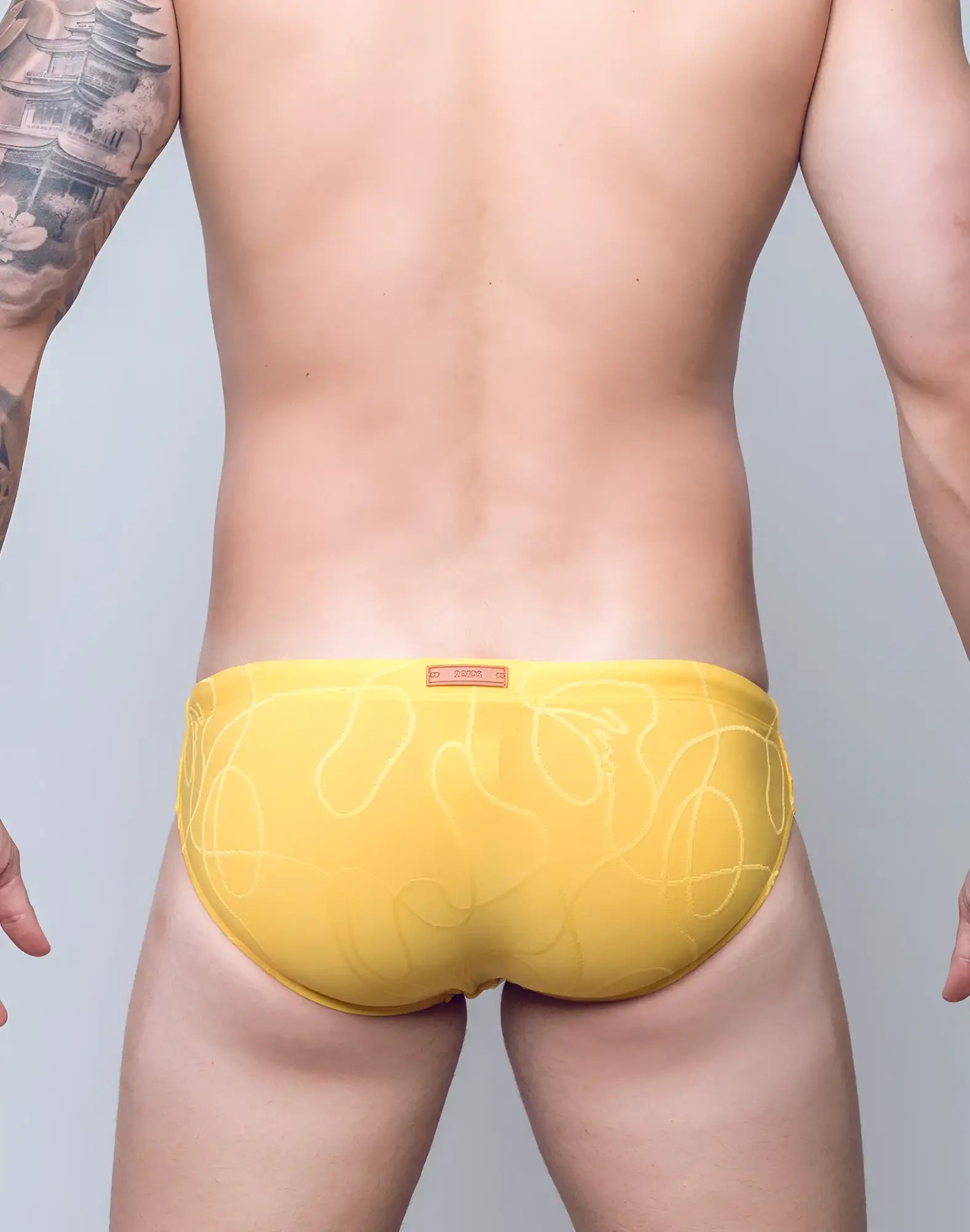 Yellow swim trunks with subtle white abstract line pattern and ripple textured fabric for swimming and beachwear
