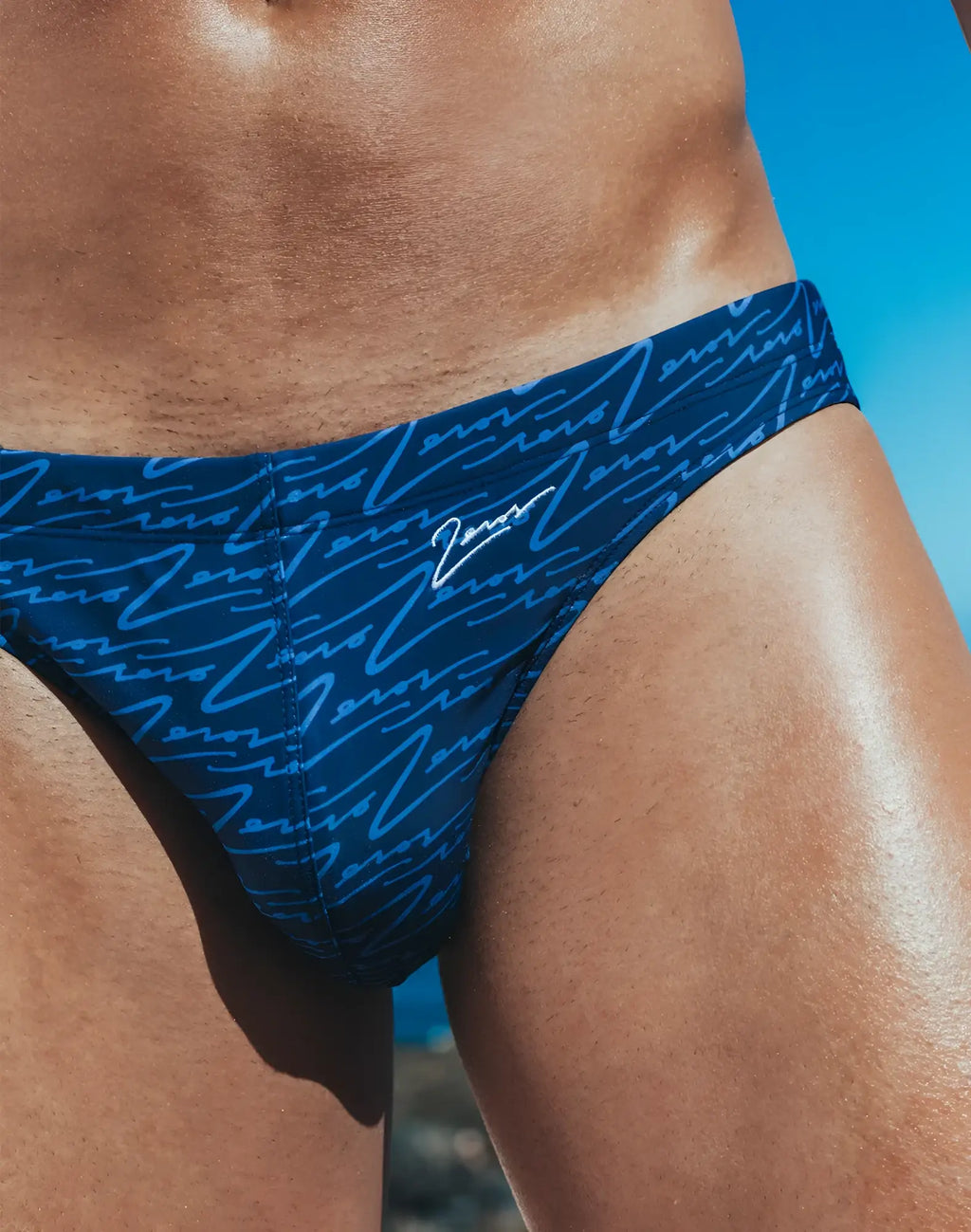 Dark blue v20 signature print swim brief with light blue cursive pattern and white zeros embroidery on waistband