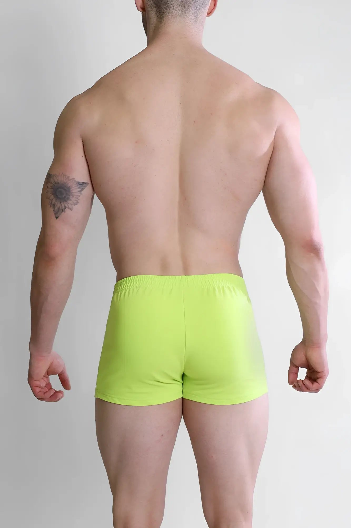Bright neon yellow varsity 2 inch short shorts with zipper pocket and snug elastic waistband for athletic use