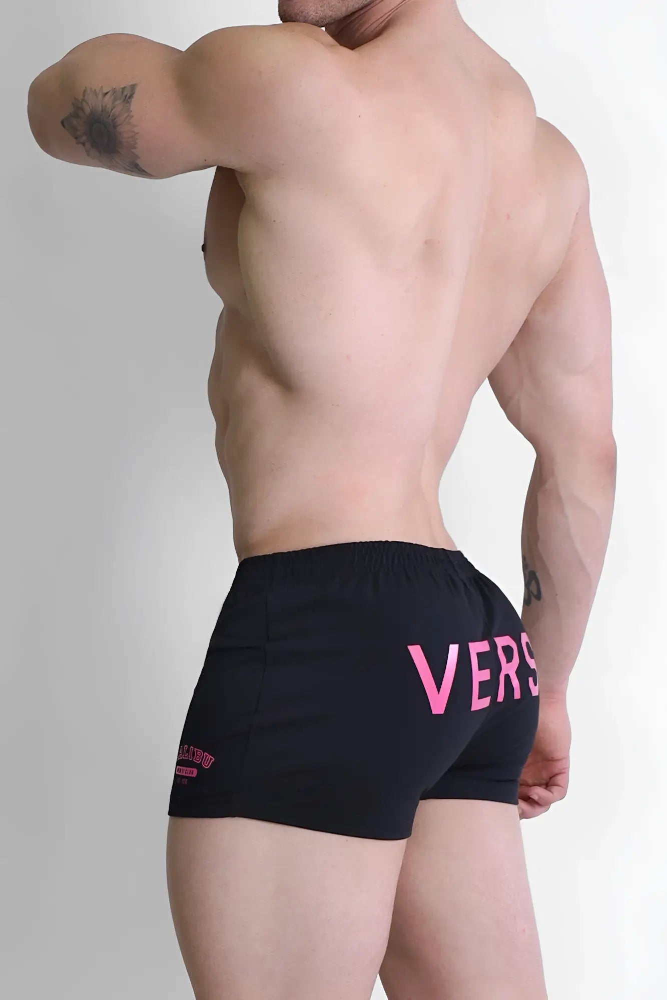 Black varsity 2 inch short shorts with zipper pocket featuring bold pink vers lettering and logo on left leg