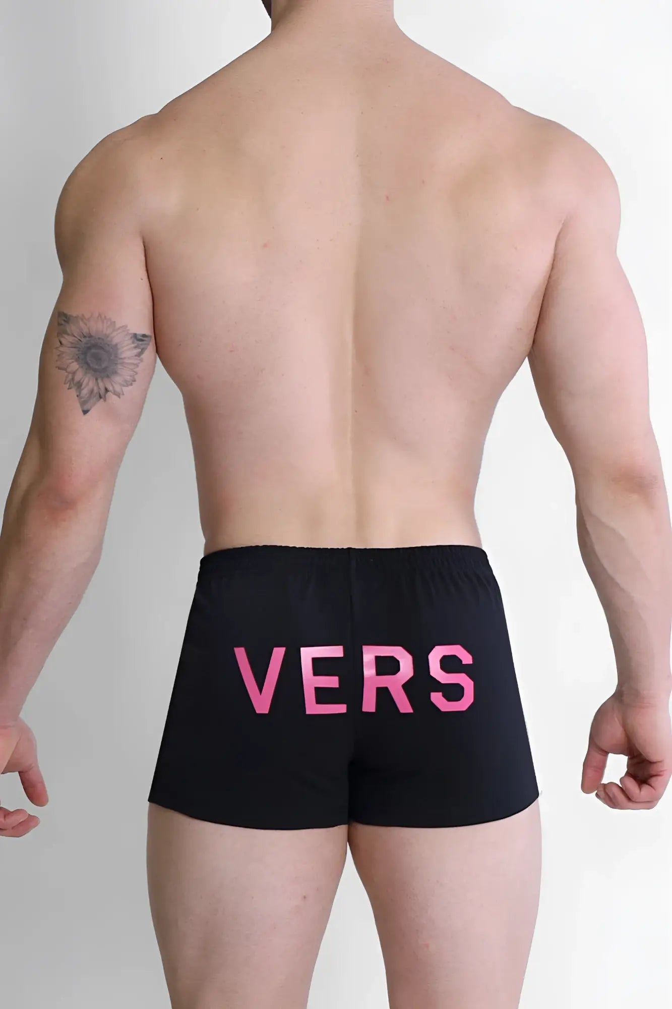 Back side of black varsity 2 inch short shorts with bold pink vers lettering and zipper pocket for versatile use