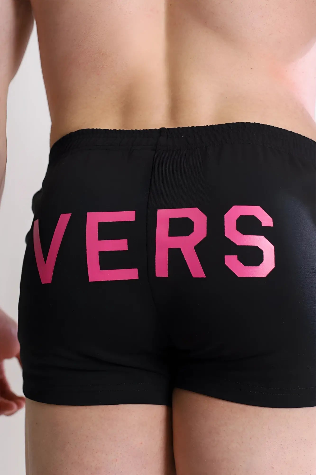 Black mens varsity 2 inch short swim trunks with bold pink vers lettering and zipper pocket on the back
