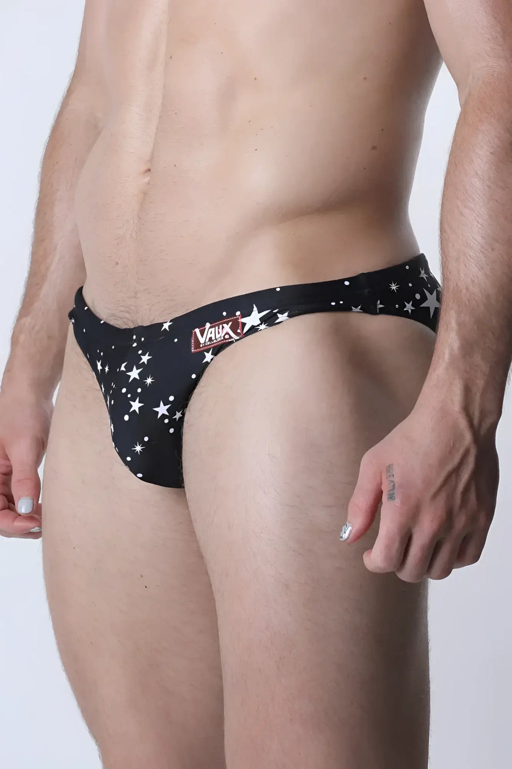 Pulse swim brief black swim trunks with white star patterns and red vaux logo on the waistband