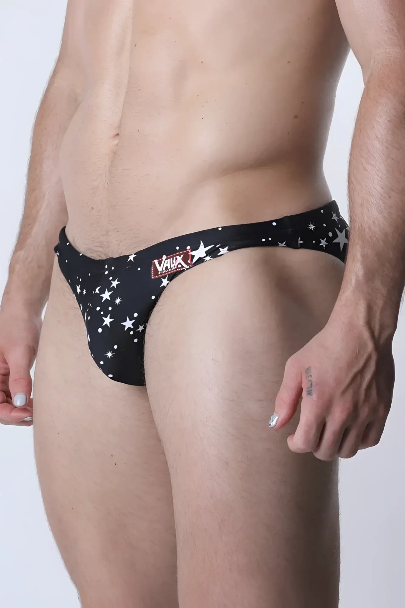 Pulse swim brief black swim trunks with white star patterns and red vaux logo on the waistband