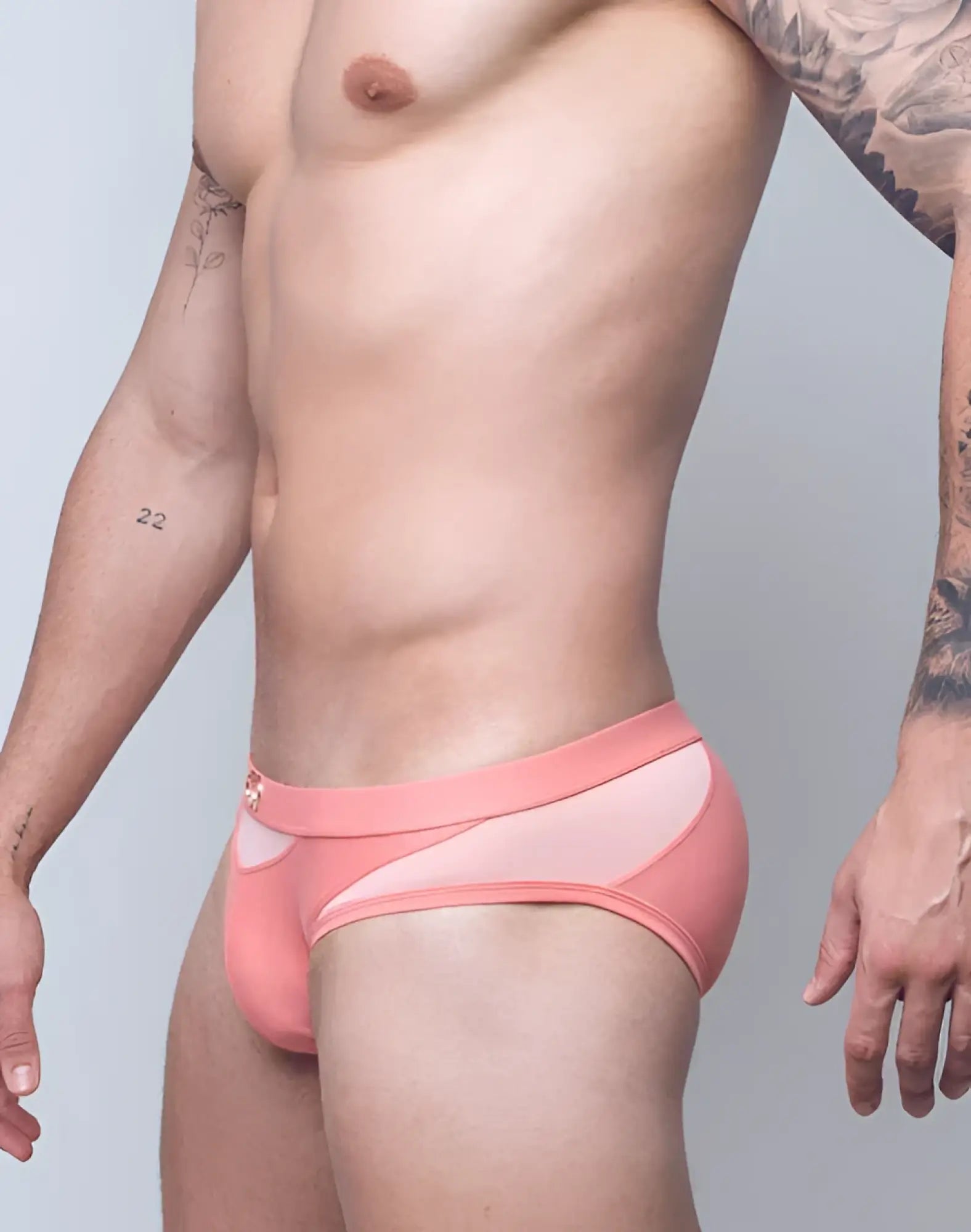 Pink vb13 swim brief with sheer mesh panel and small gold logo on waistband for athletic use