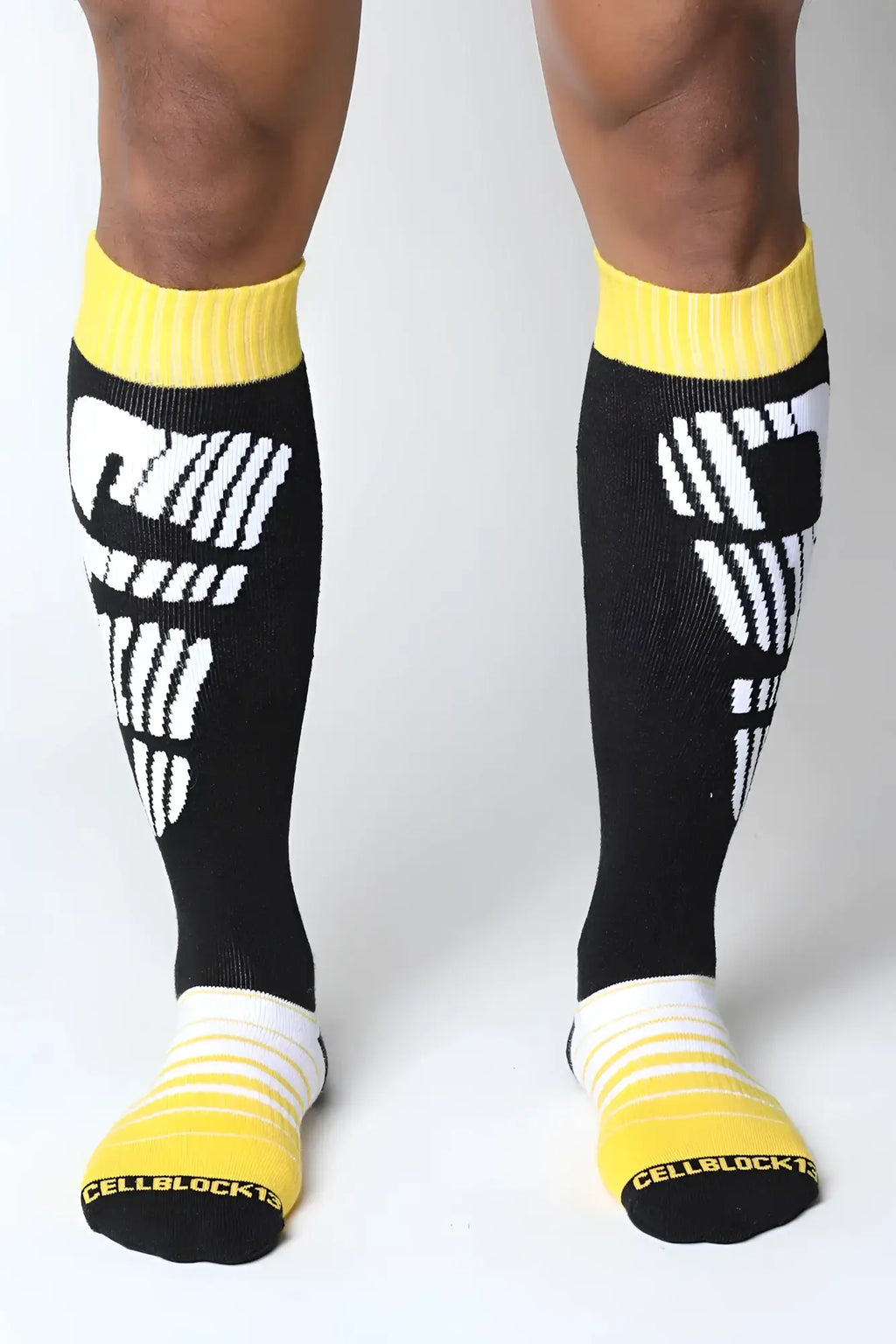 Velocity 2.0 knee high socks in black with bold white graphic design and bright yellow ribbed cuffs toe caps and heels