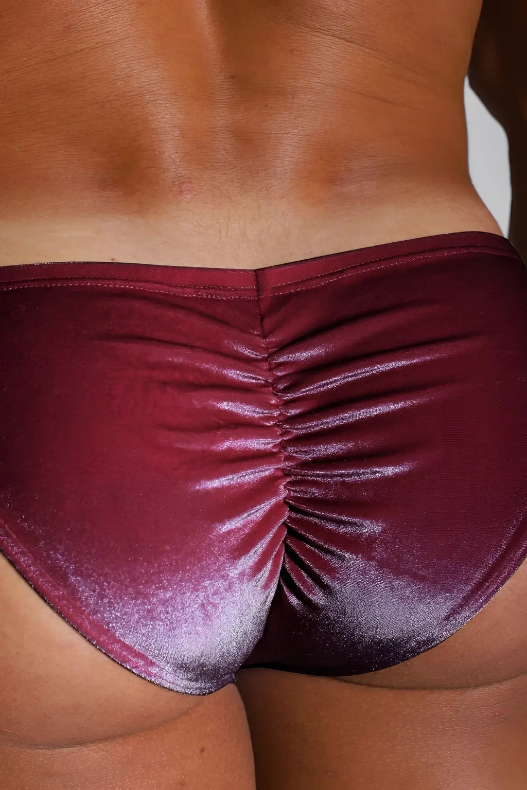Maroon metallic satin bikini briefs with a ruched back design shown from the back side