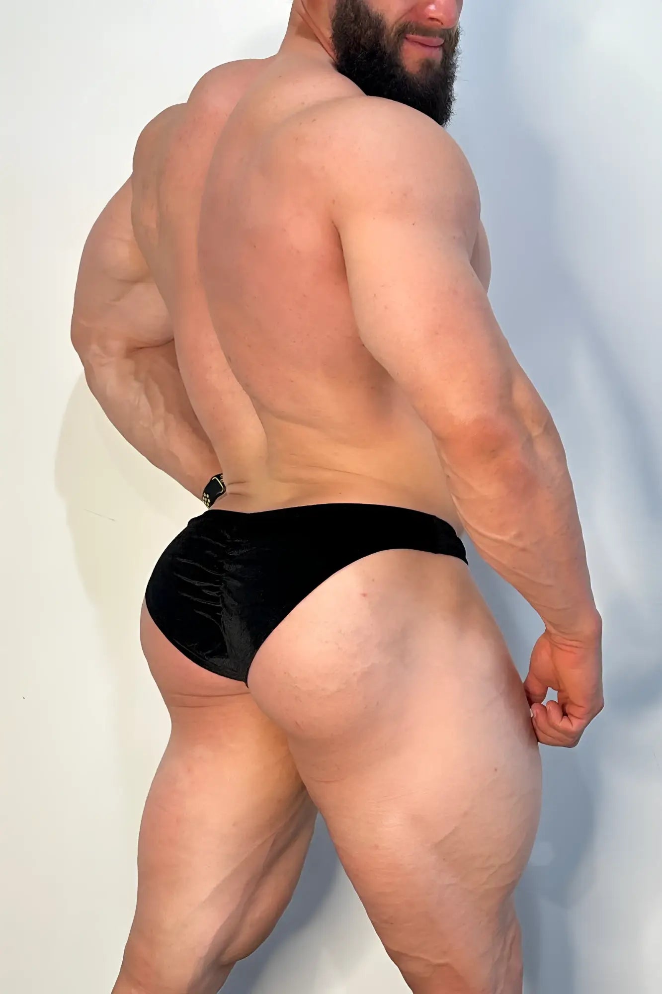 Velvety scrunch-butt bikini briefs in onyx black satin with subtle sheen and small metallic buckle at waistband back side