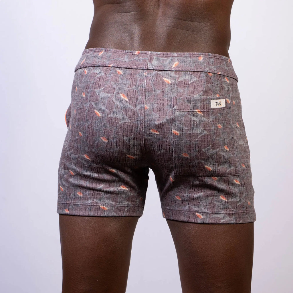 Back view of vintage stripes linen texture shorts in gray with subtle weave and orange fish motifs with branded label