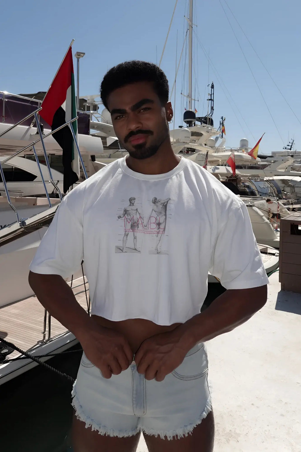 White vintage-washed drop-shoulder crop tee with graphic print of two muscular figures in gray and pink tones