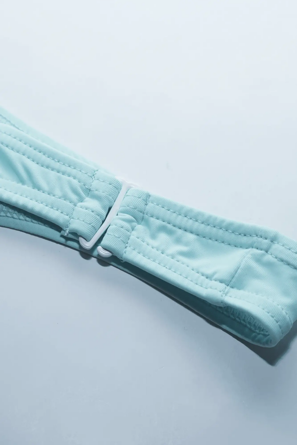 Light blue quilted strap with white plastic buckle on the back of voyage low cut swim bikini briefs for men