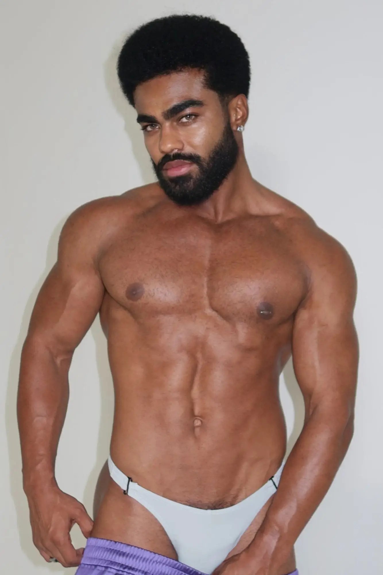 A man with a muscular build wearing pale grey voyage low-cut swim bikini briefs for men in white briefs