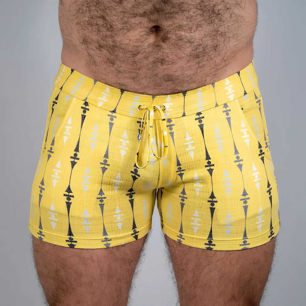 Bright yellow wallpaper print linen texture shorts with repeating black and white geometric pattern and drawstring waistband