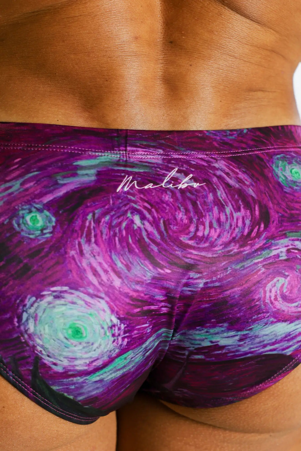 Wet-N-Wild swim briefs in vibrant purple and teal with a swirling starry night design and malibu branding
