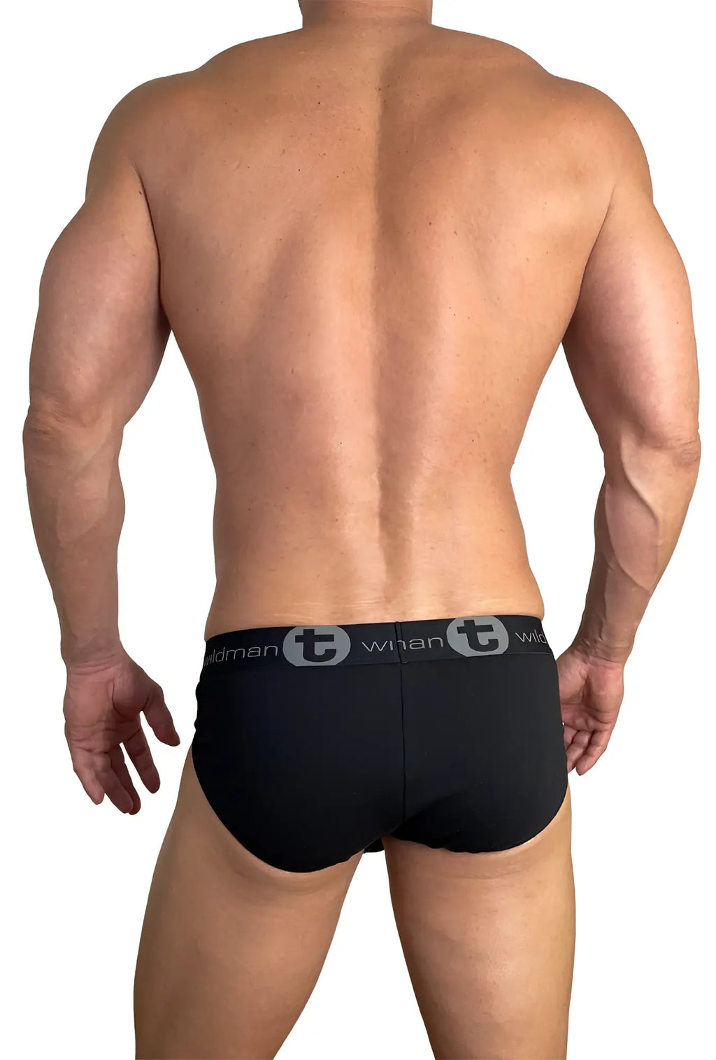 Back view of a muscular man wearing black WildmanT cotton briefs with a branded grey logo waistband.