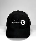 Black baseball cap with white text reading "I only wear wildmanT" and a circular logo featuring a lowercase "t".