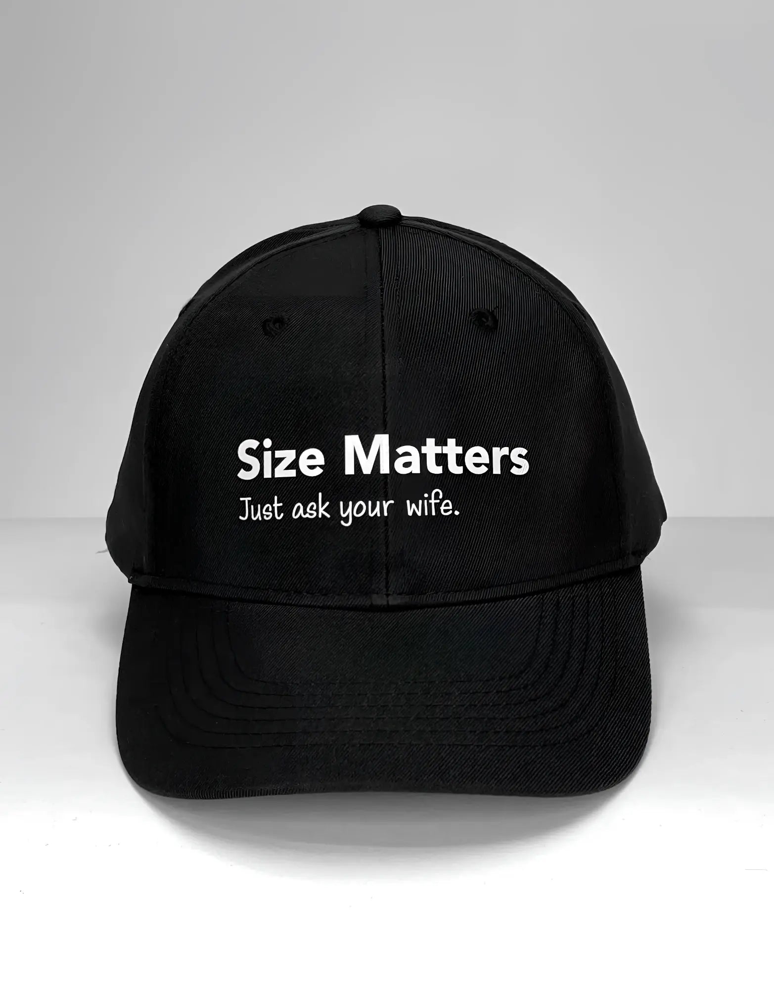 Black baseball cap with white text that reads "Size Matters" and "Just ask your wife." centered on the front.