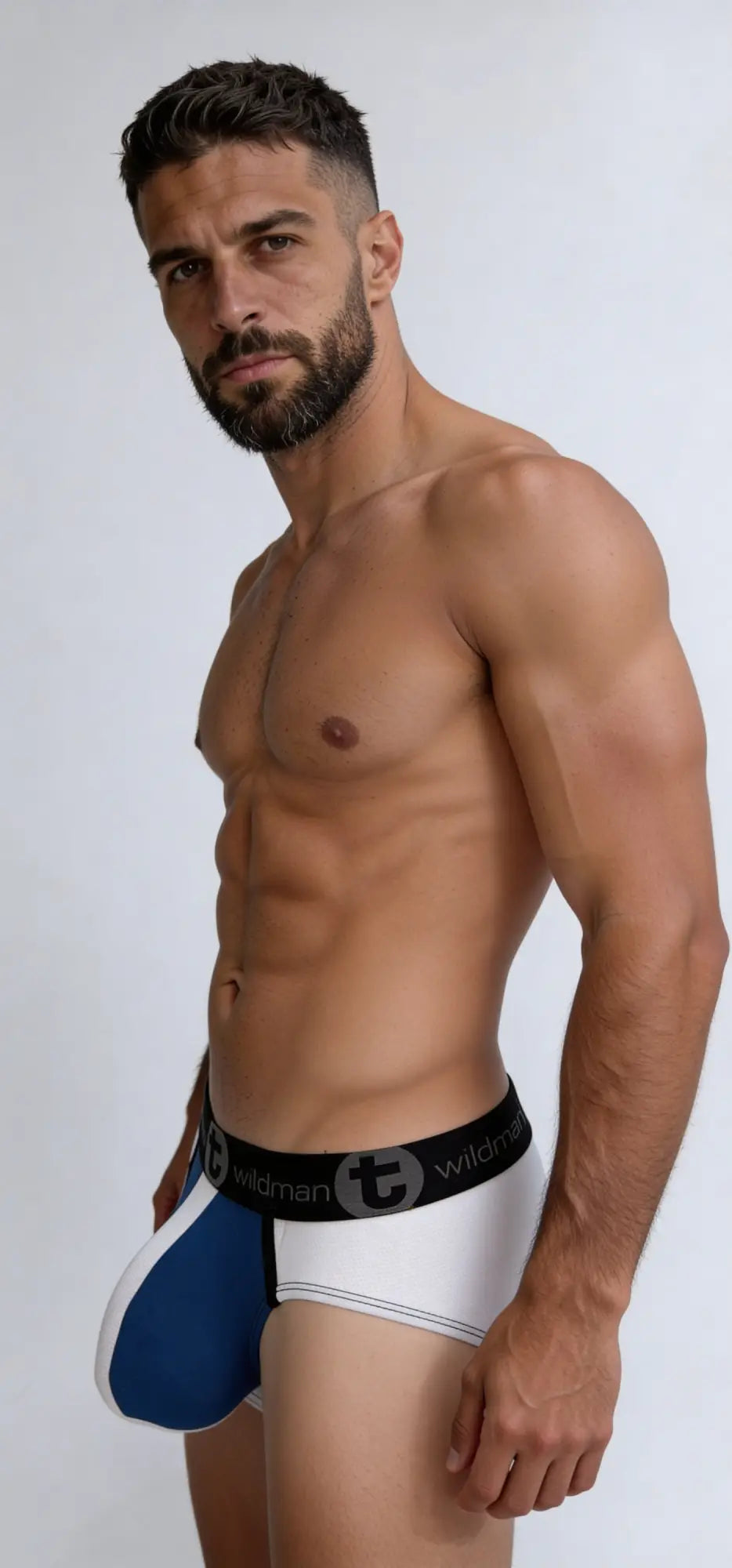 A muscular man wearing a Big Boy Pouch Brief in blue and white with a black branded waistband.
