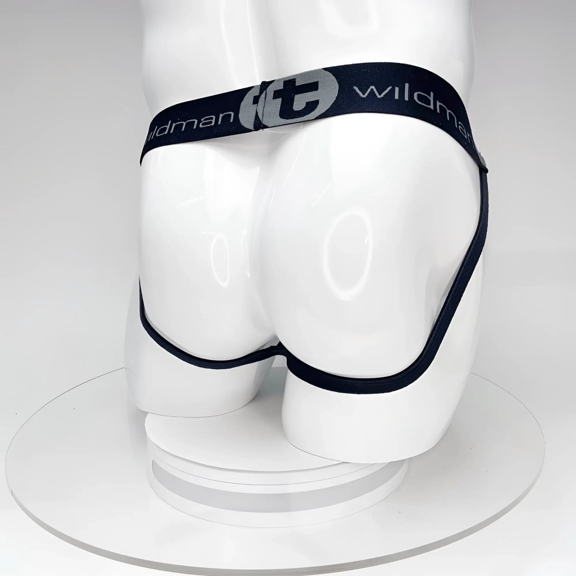 Black WildmanT jockstrap on a white mannequin, featuring a branded elastic waistband with a "t" logo and leg straps.