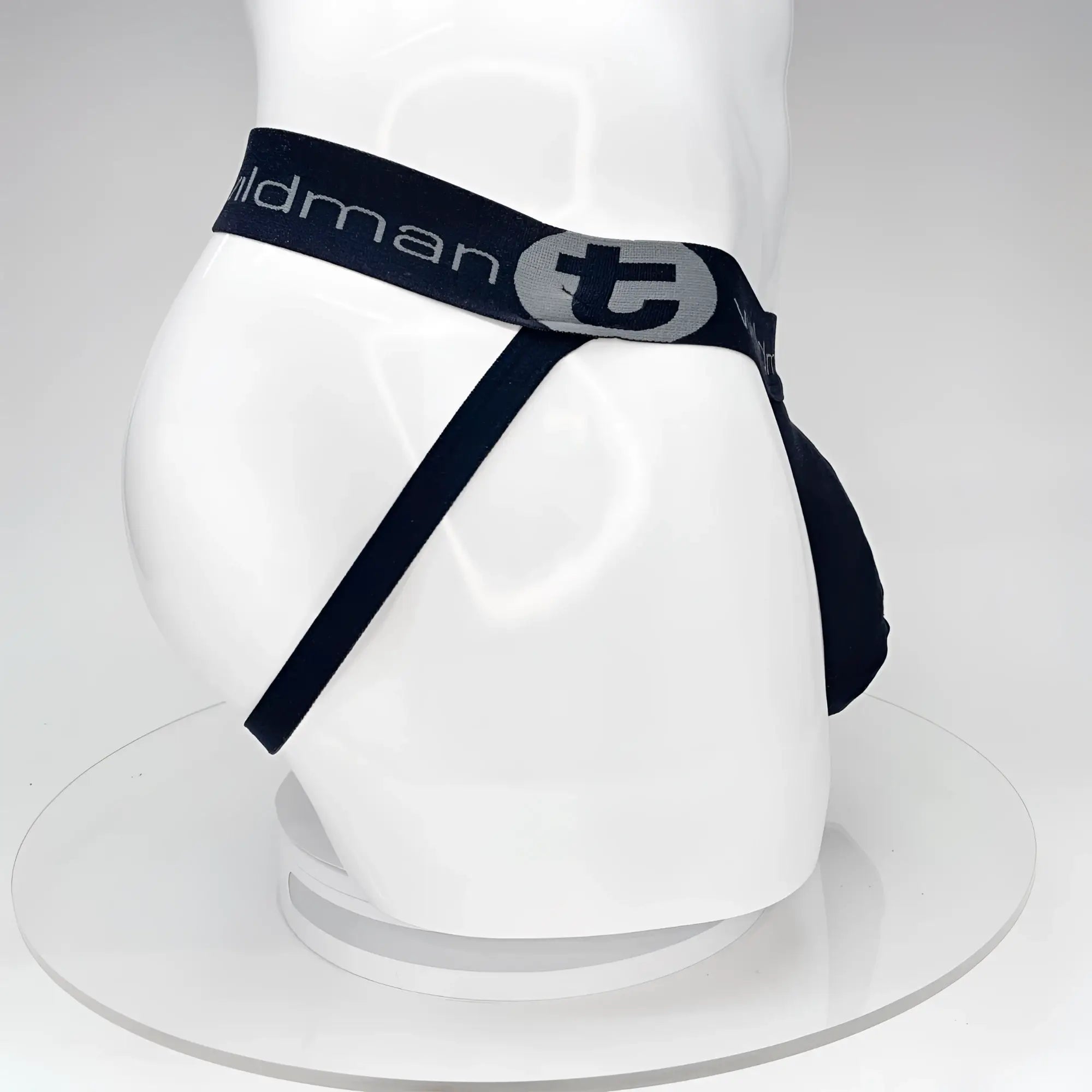 Black WildmanT jockstrap with a large front pouch and logo-branded waistband on a white mannequin.