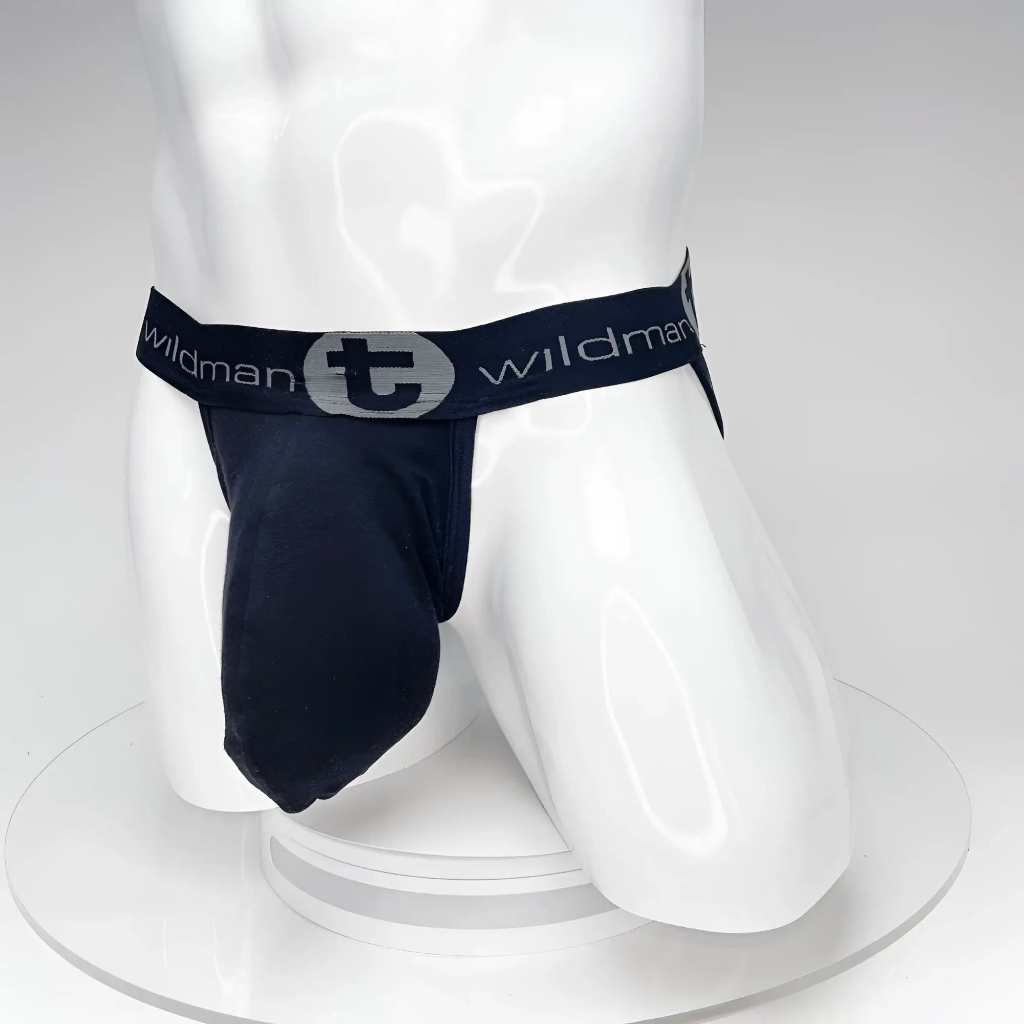 Black WildmanT jockstrap with a large front pouch and a branded elastic waistband on a white mannequin torso.