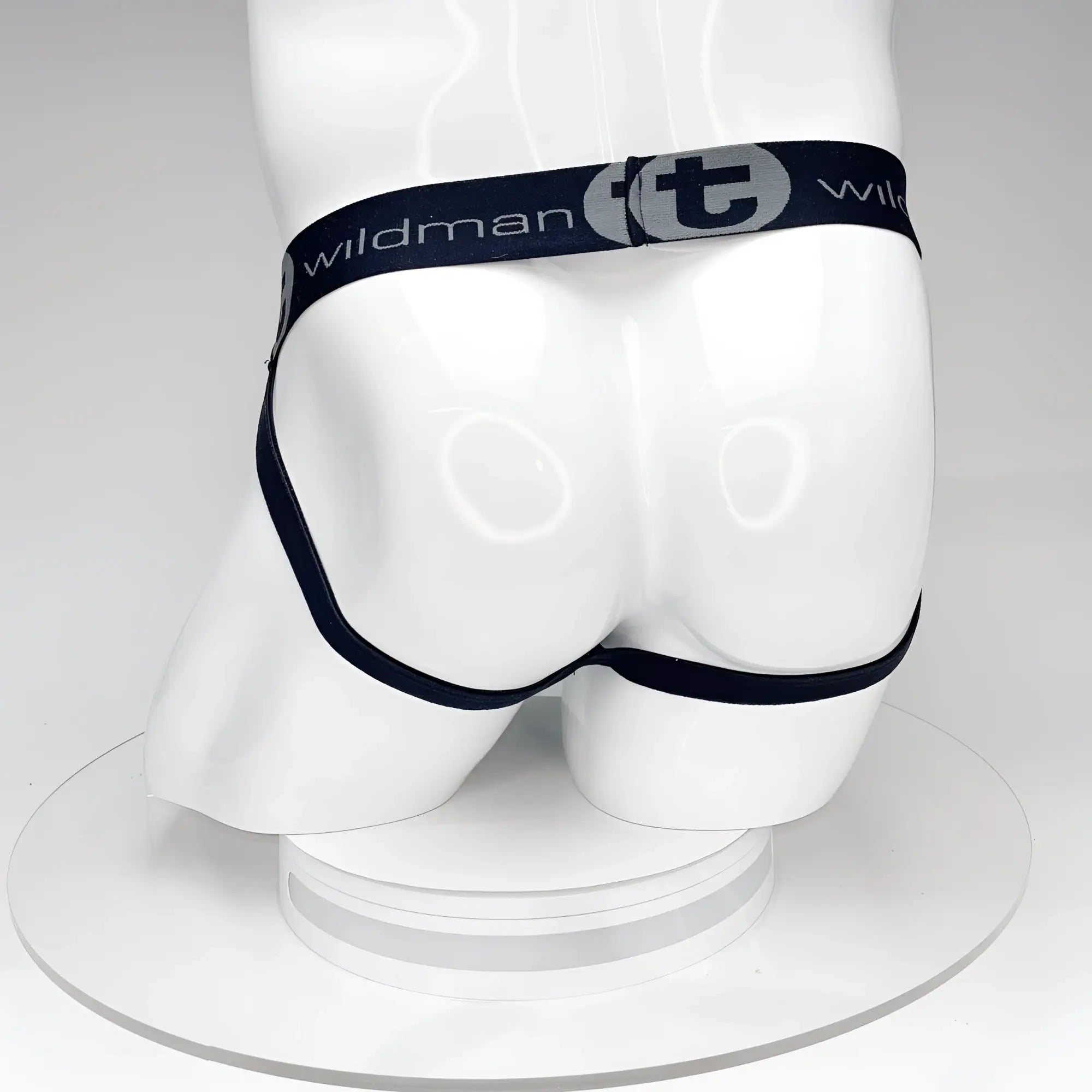 Back view of a black WildmanT jockstrap on a white mannequin, featuring a branded elastic waistband with a "t" logo.