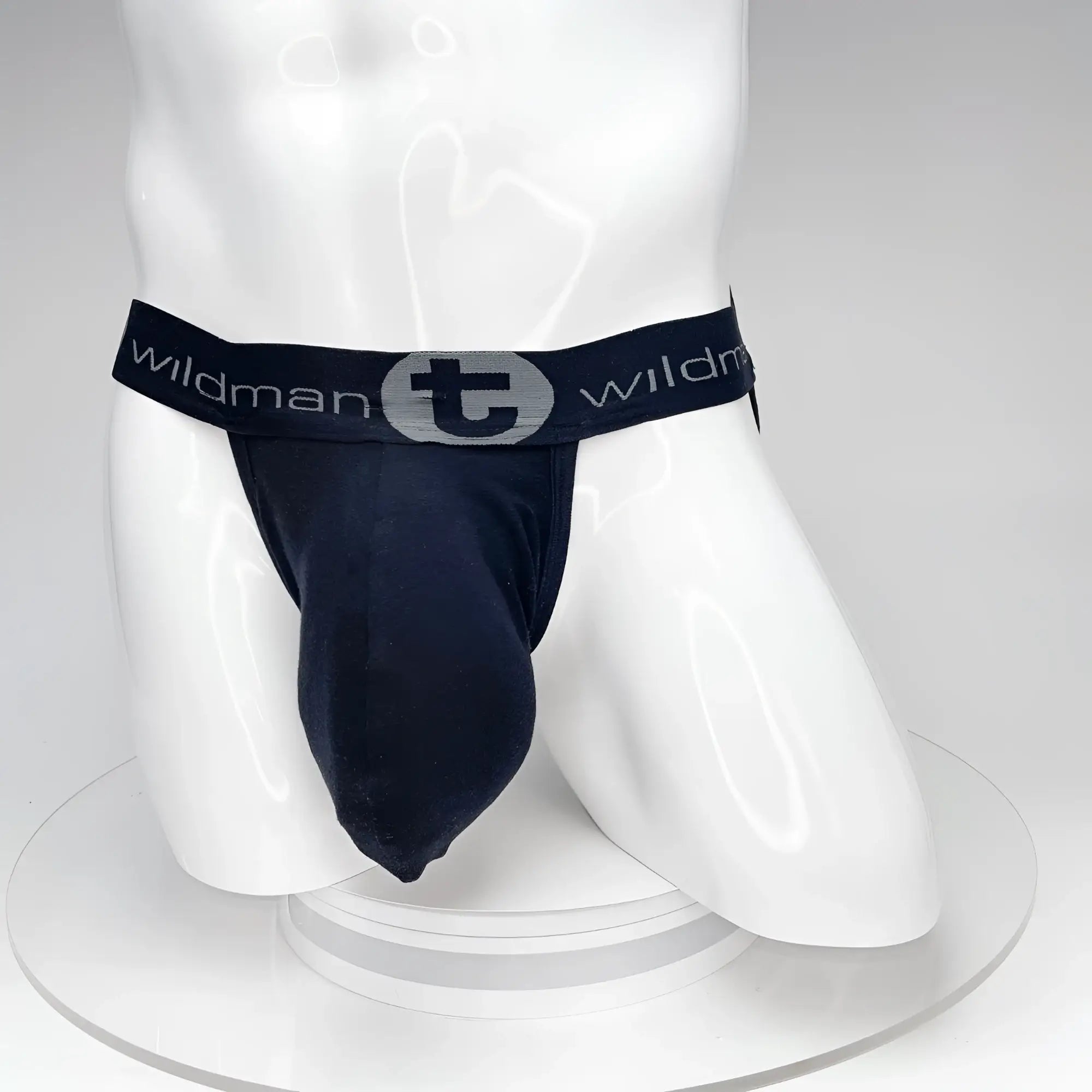 Black WildmanT jockstrap with a prominent front pouch on a white mannequin. Elastic waistband features logo branding.