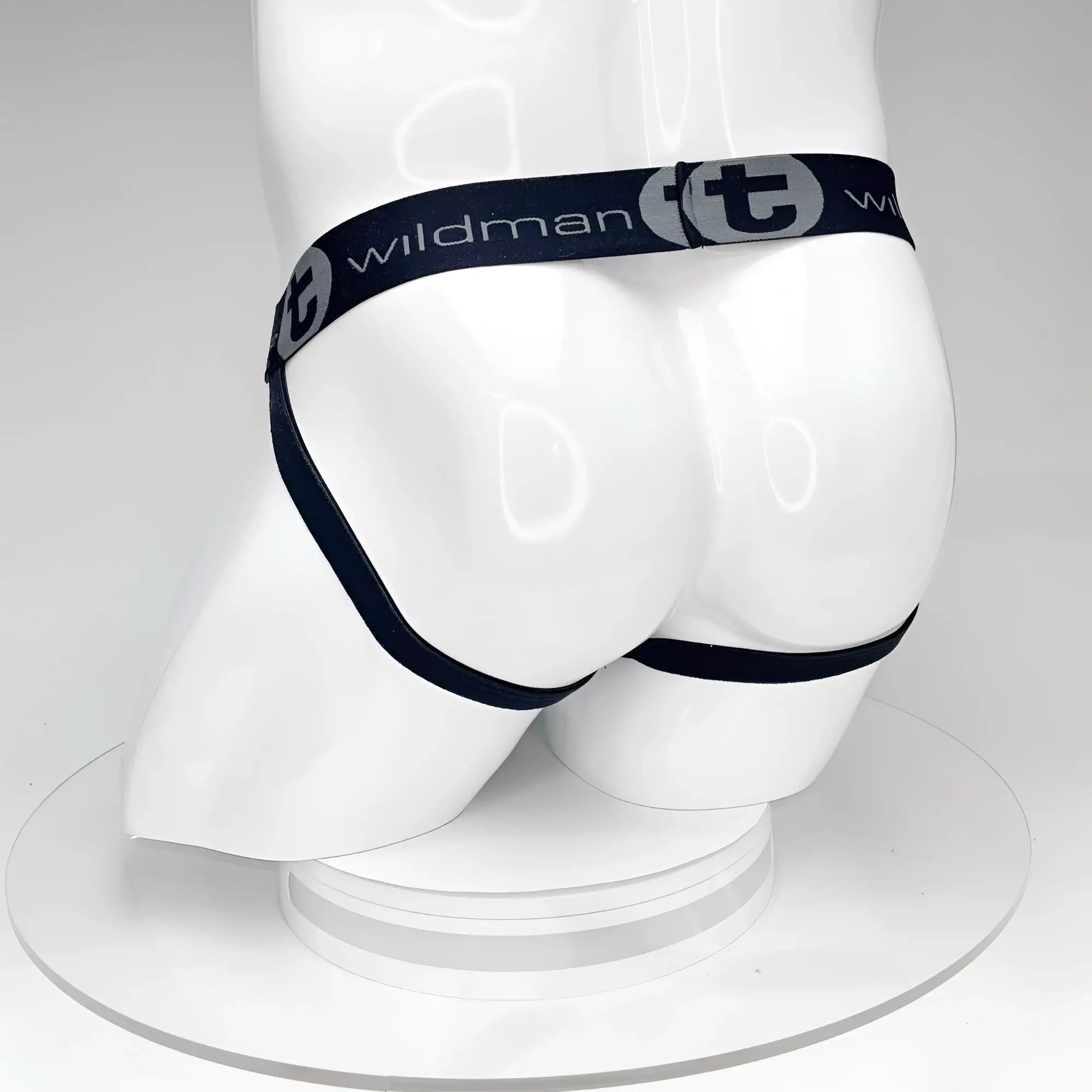Black WildmanT jockstrap on a white mannequin, featuring a branded elastic waistband with "WildmanT" logo.
