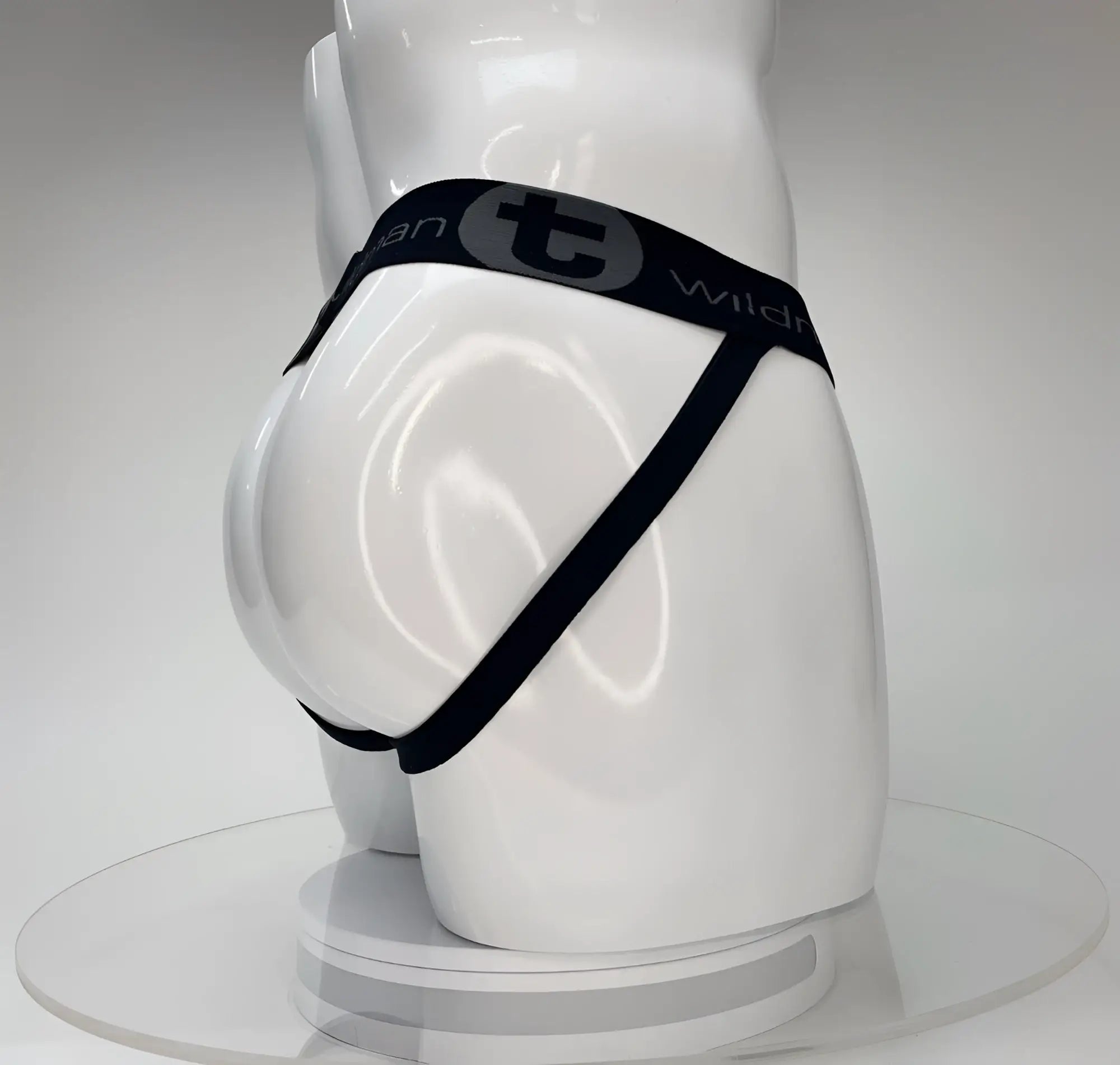 White mannequin wearing a black WildmanT jockstrap with a branded elastic waistband and side straps.