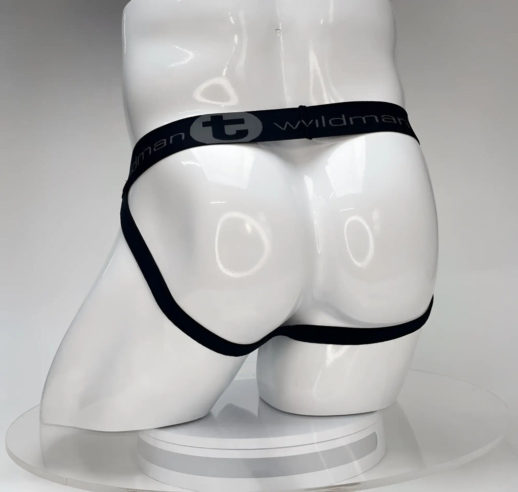 White WildmanT Big Boy jockstrap on a mannequin, featuring a black waistband with the brand name and logo.